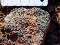 DSC1502 DxO  Un nodule de péridotite : olivine, ortho et clinopyroxènes , spinelle, ce qui signe une profondeur d'extraction comprise entre 80 et 30 km de profondeur. L'olivine est en partie altérée en iddingstite.