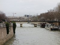 DSC2787 DxO  Depuis le pont au Double, le pont de l&#39;Archevéché dont les parapets croulent sous les cadenas. Au loin le pont de la Tournelle avec la statue de Sainte Geneviève.